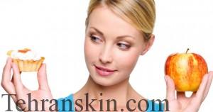 Young beautiful female choose  from sweet cake and red apple