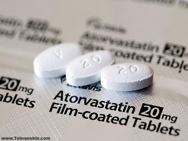 Aberdeen, Scotland - April 7, 2014: Close up view of three Atorvastatin tablets.  Atorvastatin is a member of the drug class known as statins, used for lowering blood cholesterol levels.